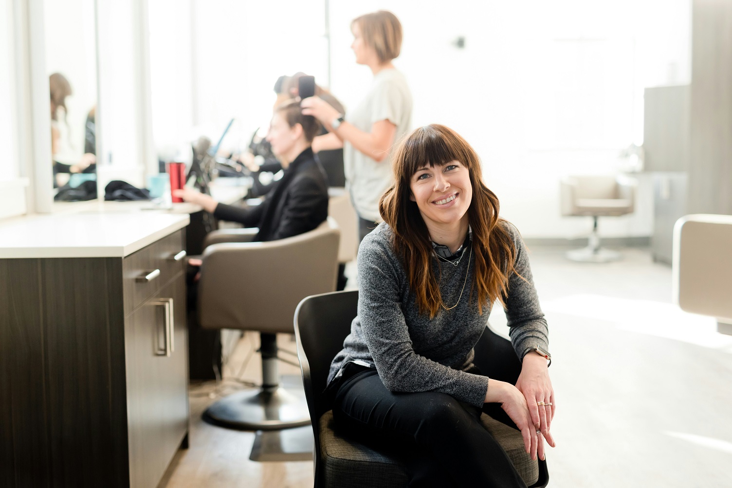 Image representing a focused or relieved salon owner